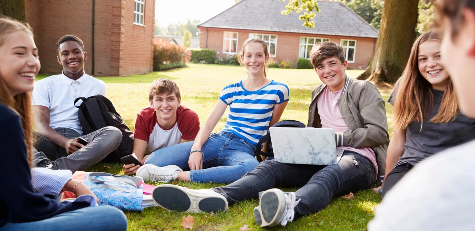 A group of teenagers studying together on the grass
