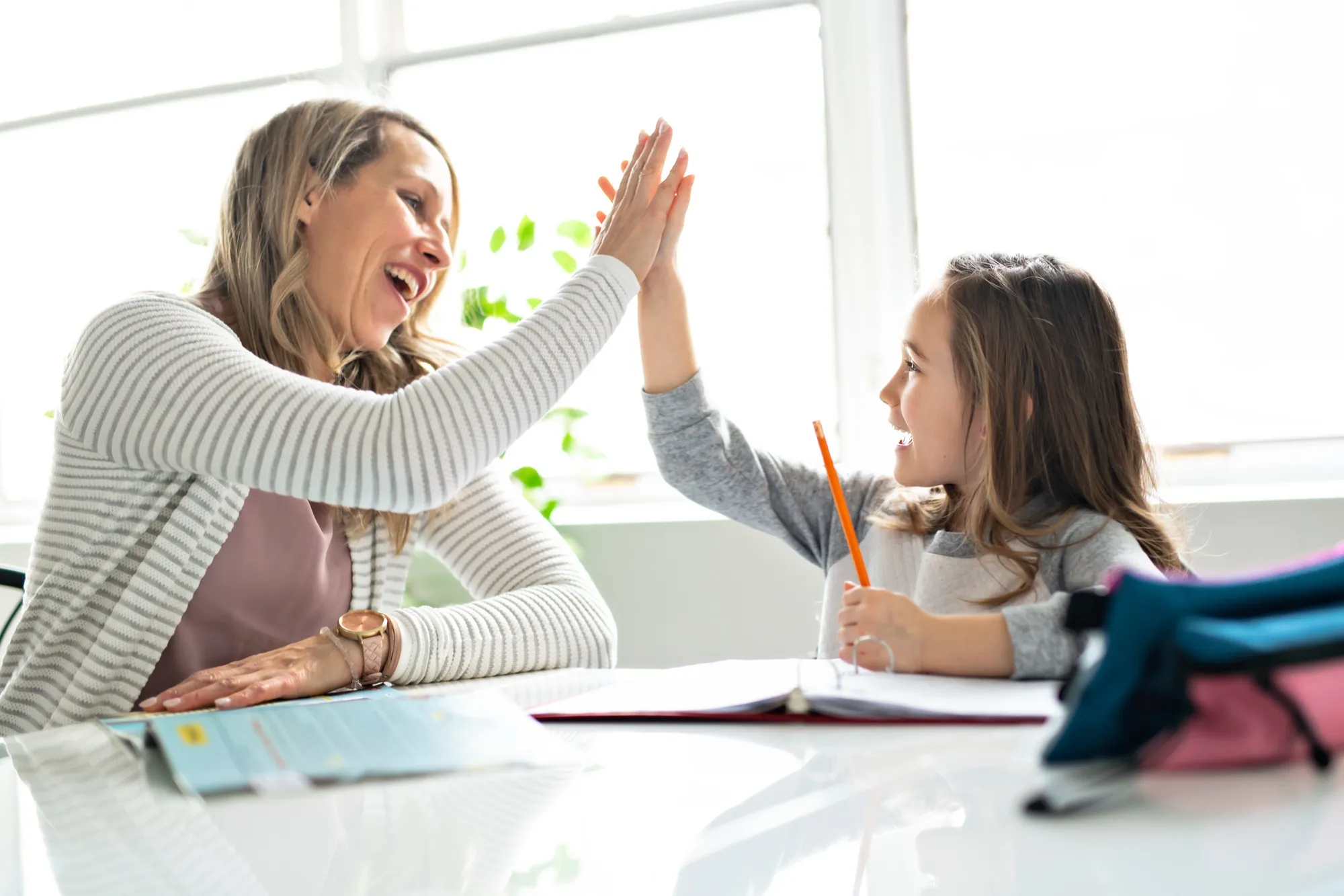 A mother helping her child with schoolwork at home